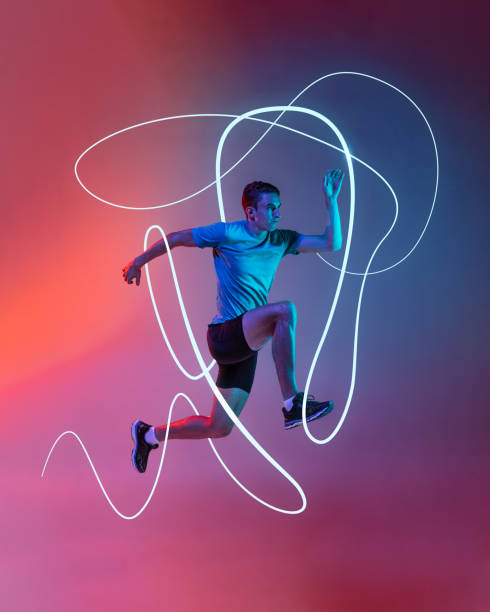 istock Dynamic image of male runner in motion, competing, neon blue and white swirls framing intensity and speed against gradient backdrop. 2200397593