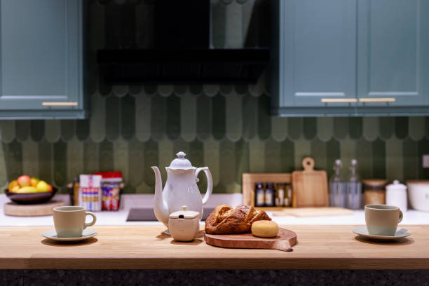 istock Kitchen with a green wall and a white tea kettle on a wooden table 2200397632