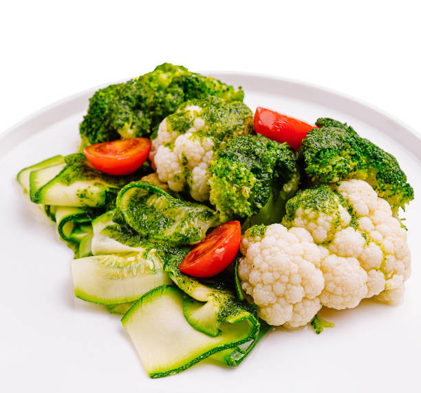istock Fresh vegetable medley featuring broccoli, cauliflower, and cherry tomatoes on a white plate 2200398162