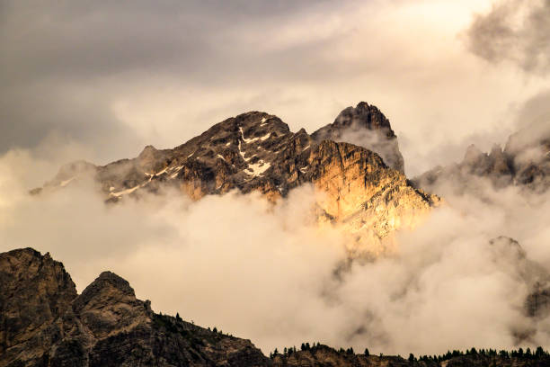 View on the Gruppo del Cristallo with the Monte Cristallo mountain range in the Italian Dolomites during a springtime sunset with clouds over the mountains.