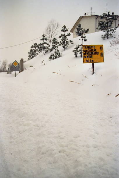 snow chains on board sign on a snow covered road