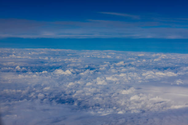 Clouds on the sky aerial view in the mountains from the plane. Blue sky and clouds below