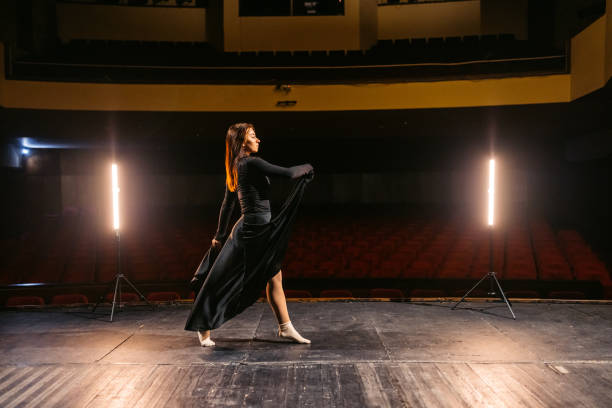 istock Young Woman Performing Interpretative Dance In An Empty Theatre 2200400828