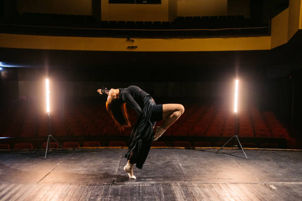 istock Young Woman Performing Interpretative Dance In An Empty Theatre 2200401367