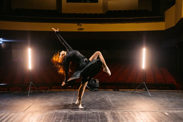 istock Young Woman Performing Interpretative Dance In An Empty Theatre 2200401455