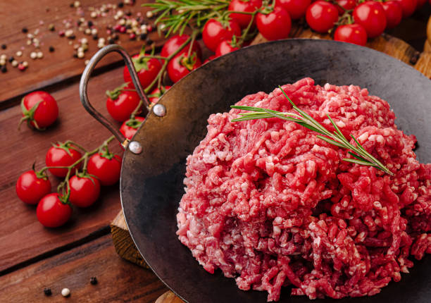 istock Fresh ground beef with herbs and vegetables on rustic wooden table 2200401671
