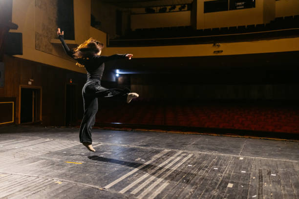 istock Young Woman Performing Interpretative Dance In An Empty Theatre 2200401711