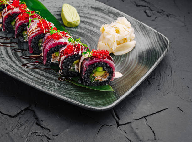 istock Colorful sushi rolls served on a decorative plate with garnishes in a modern restaurant setting 2200402063