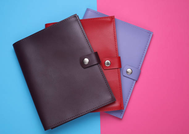 Leather notebooks or document organizers on blue pink background