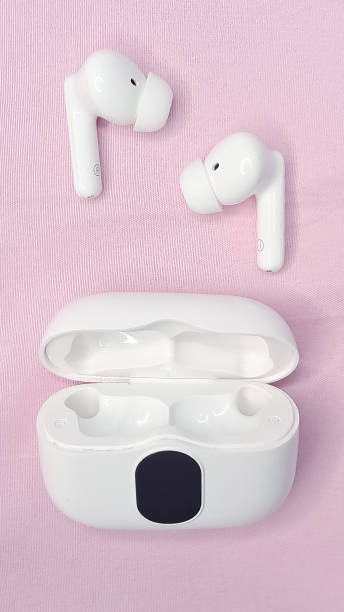 istock Modern wireless headphones on a pink background, minimalistic style. 2200409439