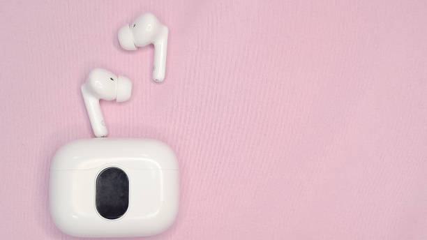 istock Modern wireless headphones on a pink background, minimalistic style. 2200409451