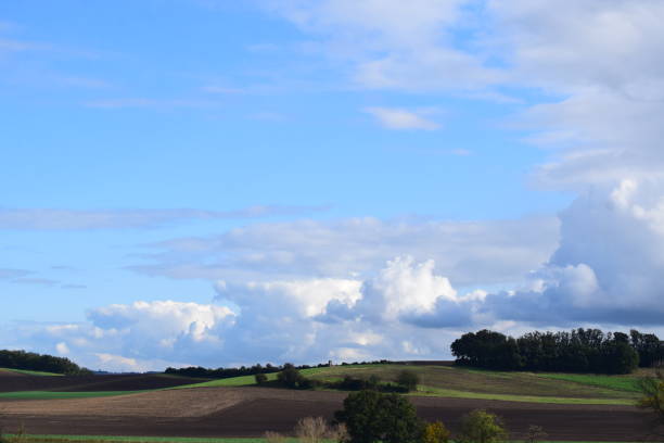 istock blue sky and big clouds above autumn farmland 2200417056