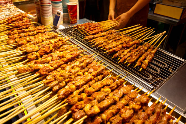 A man barbecued mutton kebabs at the night market