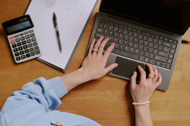 istock Working on Laptop with Notepad and Calculator Nearby 2200418559