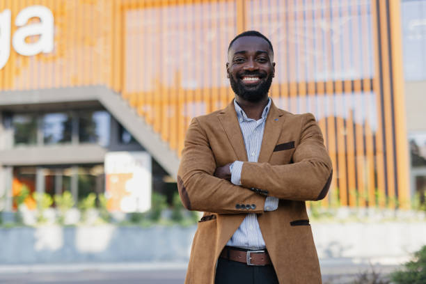 istock Confident Businessman Smiling Outside Modern Office Building 2200428691