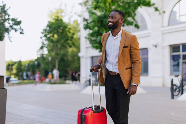 istock Young Professional Traveling with Red Suitcase 2200428754