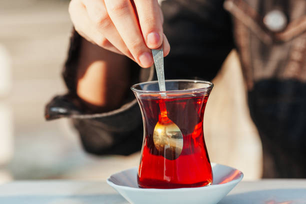 istock Woman’s Hand Stirring Traditional Turkish Black Tea, Close-Up Shot 2200429137