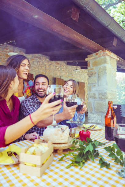 istock Friends toasting red wine at countryside lunch table 2200430390