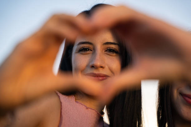 istock A woman is making a beautiful heart shape using her hands to express love 2200438046