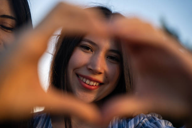 istock A woman creates a heart shape using her hands in a joyful way 2200438066