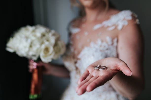 istock Bride Holding Wedding Rings in Her Hand 2200438425