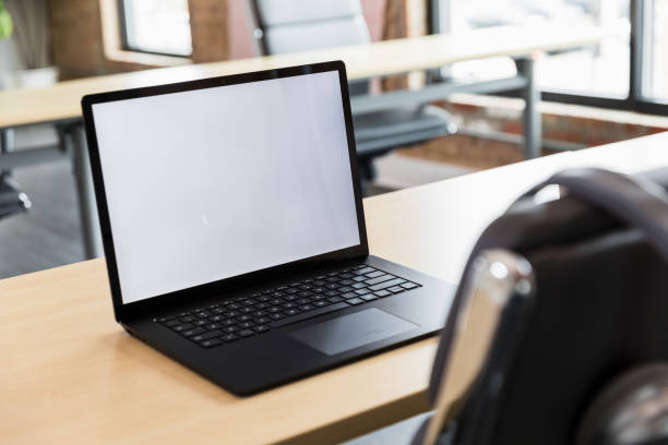 Blank laptop screen on a desk in a modern office. Copy space.