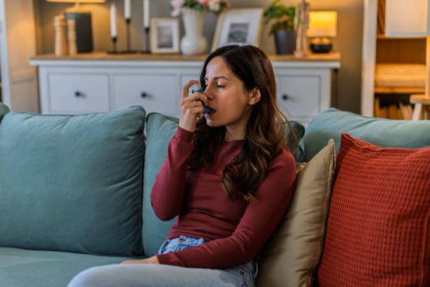istock Young woman using her asthma inhaler at home 2200446541