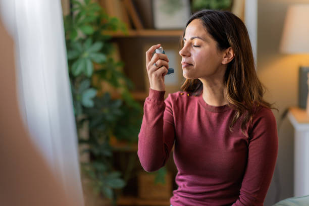 istock Young woman using her asthma inhaler at home 2200446853