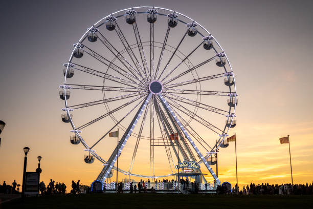 Ferris wheel with its hanging cabins at sunset