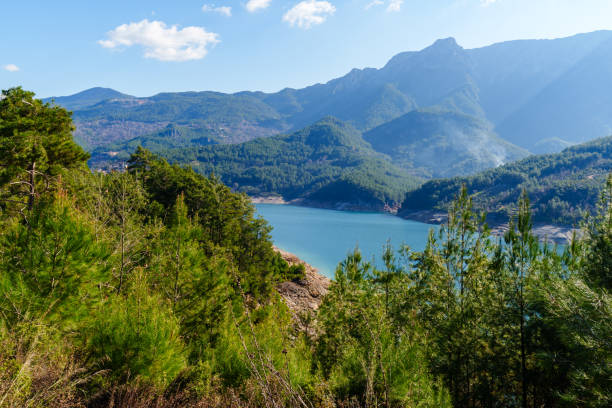 istock Scenic Lakeside View with Forests and Mountains Under Clear Blue Sky 2200457027