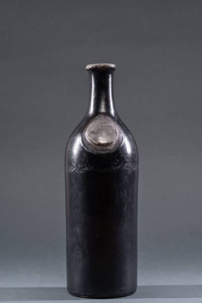 istock Unique black ceramic bottle with a round neck and smooth surface displayed against a gray background in a studio setting 2200458796