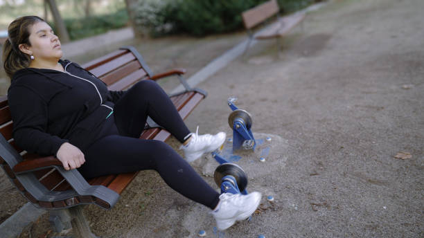 Young woman exercising her legs on a pedal machine in a public park