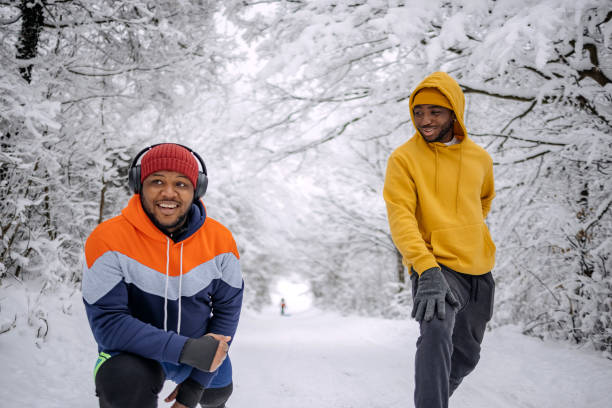 istock Friends exercising on snow in winter and having fun while stretching 2200463034