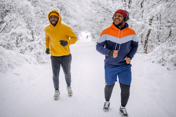 istock Friends exercising on snow in winter and having fun while jogging 2200463075