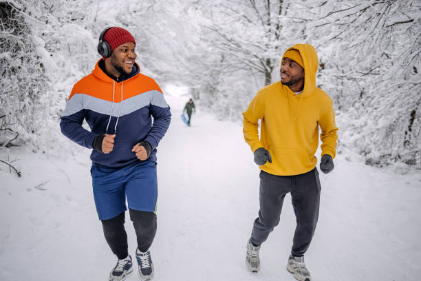 istock Friends exercising on snow in winter and having fun while jogging 2200463089