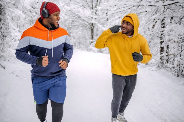 istock Friends exercising on snow in winter and having fun while jogging 2200463093