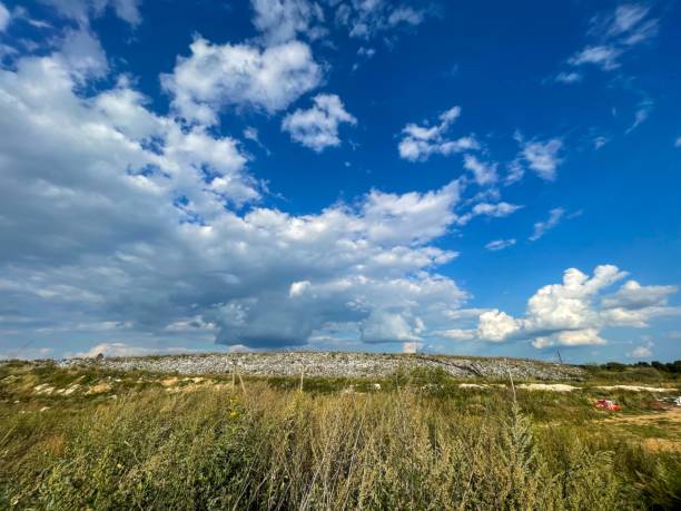 istock A rocky hill is prominent under a brilliant blue sky, with fluffy clouds overhead, surrounded by lush green vegetation 2200464004