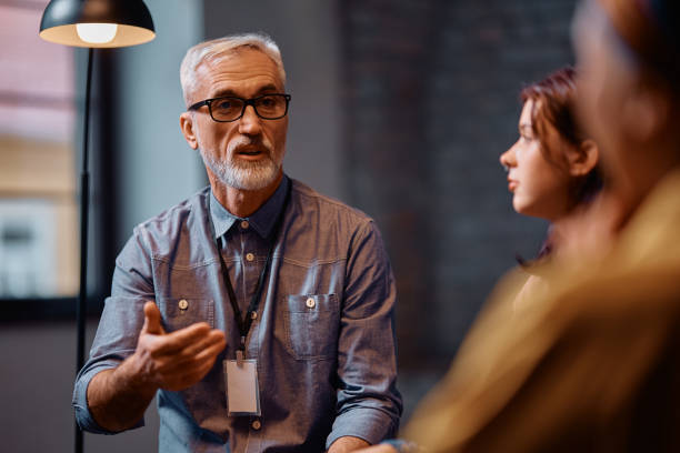istock Mental health professional talking during a group therapy at counseling center. 2200467340