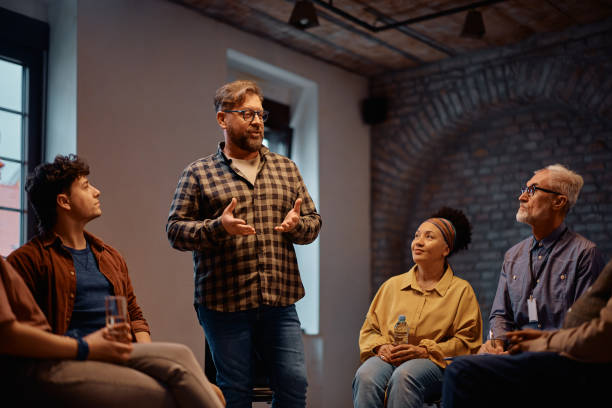 istock Mature man sharing his personal issues with attendees of group therapy at community center. 2200467609