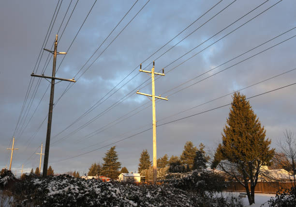 Surrey, Canada - February 4, 2025: Dramatic sky above the Green Timbers Greenway in Metro Vancouver. An electrical grid extends through the Fleetwood neighbourhood of detached houses. Winter sunrise.