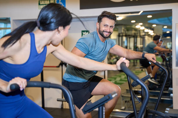 Energetic young adults exercising on stationary bikes
