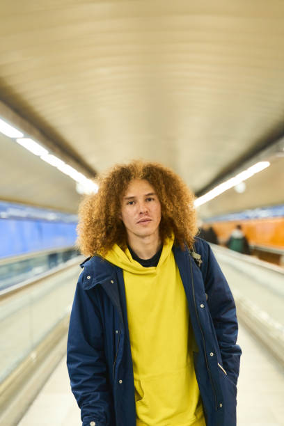 Young man walking in urban subway corridor
