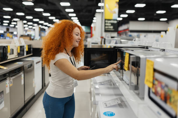 istock Woman Examining Microwave in Appliance Store 2200476232