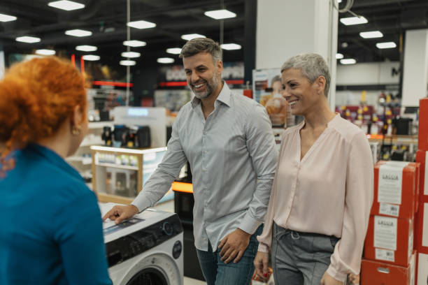 istock Happy Couple Exploring Home Appliances with Staff 2200476379