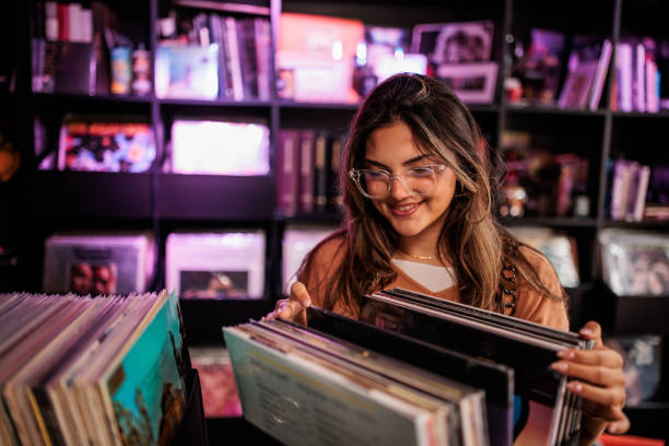 istock Beautiful Woman Selecting Records at Vinyl Store 2200485976