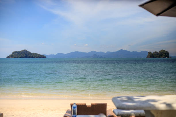 Beachside chair and table with beach and sea background. Relaxation beach view. Lifestyle resort. Depth of field concept.