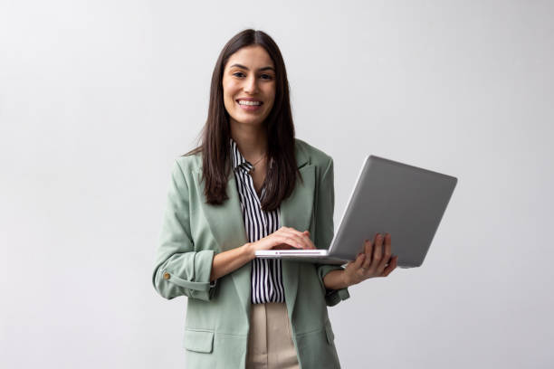 istock Ambitious Latina business leader working on a laptop while carrying it 2200495804