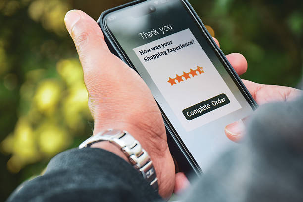 istock Man holding phone displaying customer feedback rating page on his mobile screen. Selective focus, digital marketing concept. 2200496357