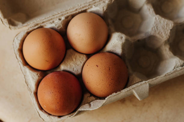 istock Overhead shot of four brown eggs in mostly empty egg carton 2200497522