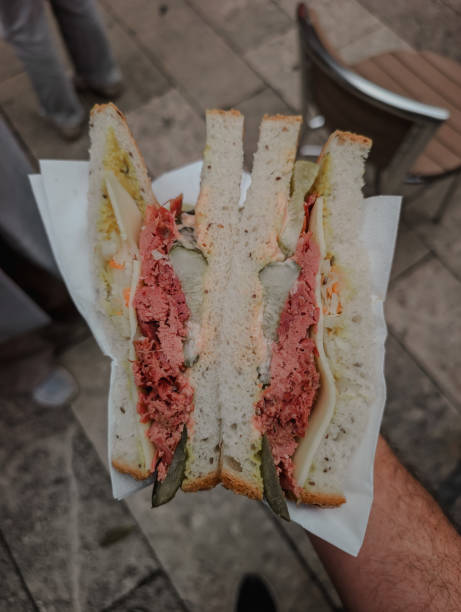 istock Reuben sandwich cut in half and held in hand 2200497844